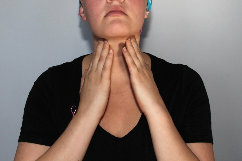 A lady feels her lymph nodes on her neck